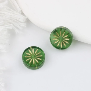 Detailansicht grüner Glasperlen mit goldenem Sternenmuster für DIY-Schmuckherstellung