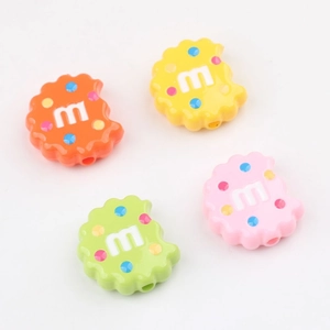 Close-up of colorful acrylic cookie beads with m-letter and polka dot patterns for DIY jewelry