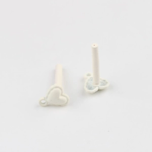 Detail of white matte lacquer heart-shaped jewelry components for DIY earrings and crafts