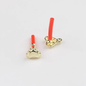 Detail of gold heart charms showing smooth front and textured back for jewelry making