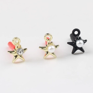 Detailed view of star-shaped jewelry charms featuring inlaid pearls and zircon stones