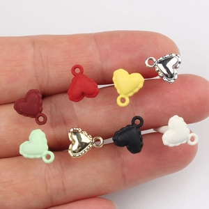 Colorful alloy heart pendants with lace edges for DIY jewelry making held in hand