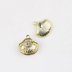 Close-up of golden alloy shell charms with pearl inlay and radiant textured details