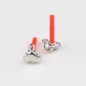 Close-up of polished heart-shaped metal charms with loop for DIY jewelry making