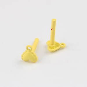 Macro detail of yellow matte heart earring components with wavy edges and metal posts