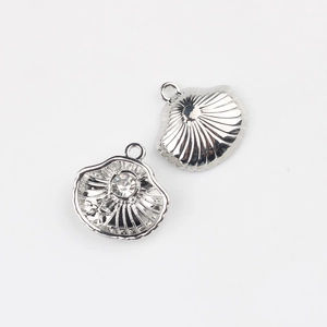 Macro view of silver shell pendants with zircon inlay and starfish detail for jewelry