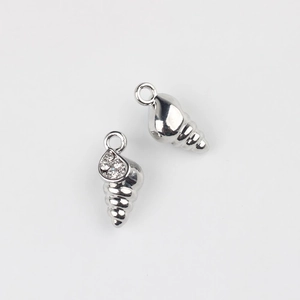 Dettaglio macro di ciondoli a conchiglia in argento con zirconi e anello per gioielli DIY