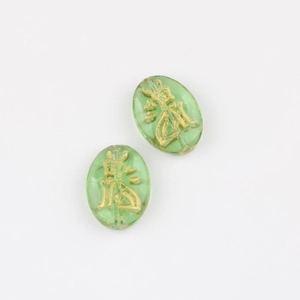 Macro view of green Czech glass oval beads with gold Egyptian Anubis patterns
