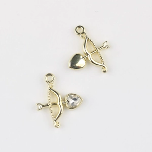 Detailed view of cupid's arrow charms with heart zircon inlays for DIY jewelry making