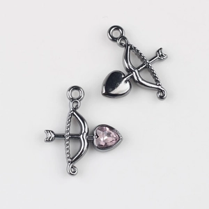 Detail of gunmetal Cupid's arrow charms with pink heart zircon for DIY jewelry making
