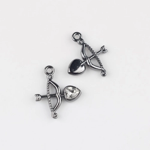 Detailed view of gunmetal alloy Cupid arrow pendants with inlaid heart cubic zirconia