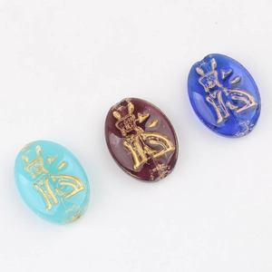 Macro detail of oval Czech glass beads with gold Fu character for DIY jewelry making