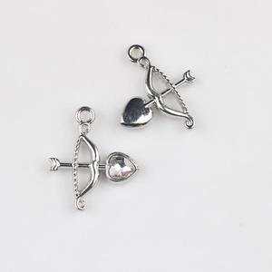 Detailed view of Cupid arrow and heart pendant charms with inlaid zircon for DIY jewelry