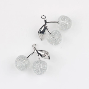 Macro shot of silver cherry pendants with glitter filled resin for DIY jewelry making