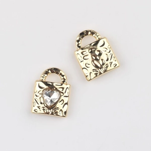 Detail of gold heart padlock pendant with hammered texture and clear zircon inlay