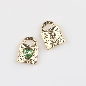 Macro view of gold alloy heart lock pendants with green crystal and leopard texture