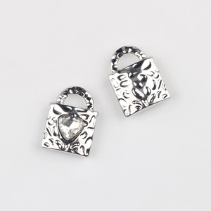 Detail of silver heart lock pendant with cubic zirconia and hammered texture