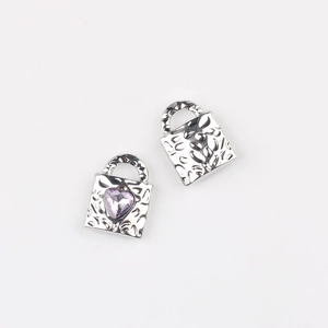Detailed view of silver heart-shaped lock pendants with purple zircon and relief texture
