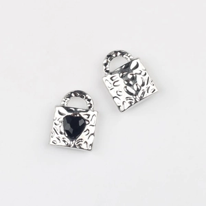 Detail of silver alloy heart lock pendant with black zircon and hammered texture finish