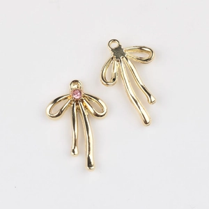 Détail macro de pendentifs nœuds dorés avec zircon rose pour création de bijoux