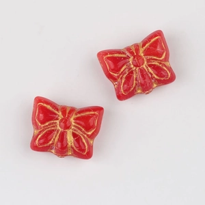 Macro view of vintage red glass butterfly beads with detailed gold hand-painted wing textures