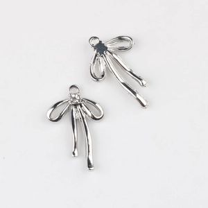 Détail de breloques nœud argentées avec zircon pour création de bijoux DIY
