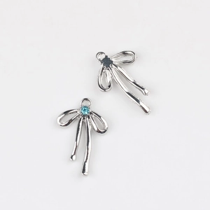 Détail de breloques nœud argentées avec zircon bleu pour la création de bijoux DIY