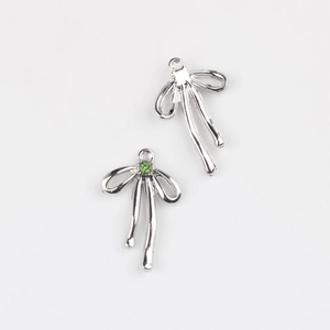 Détail du pendentif nœud argenté avec zircon vert montrant l'avant et l'arrière