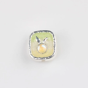 Detail of silver square bead with silver rabbit motif and light yellow resin inlay for DIY