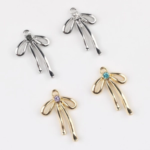 Détail de breloques en forme de nœud avec strass colorés pour bijoux DIY