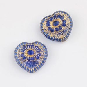 Detail view of heart-shaped blue Czech glass beads with vintage gold floral patterns