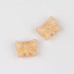 Macro shot of two vintage pink glass butterfly beads with gold edges for DIY jewelry