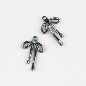 Détail de pendentifs en alliage en forme de nœud avec zircon bleu clair et placage fusil