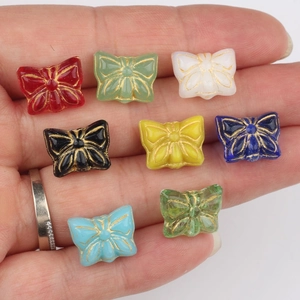 Handheld vintage butterfly glass beads with gold outline in assorted vibrant colors