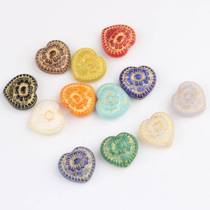 Detailed view of colorful heart-shaped glass beads with floral patterns and gold gilding