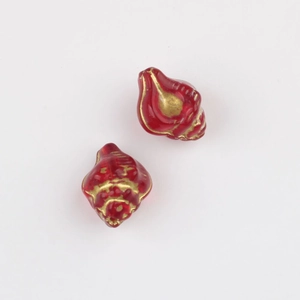 Macro detail of red conch-shaped glass beads with vintage gold rim for DIY jewelry