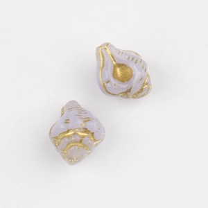 Macro detail of lavender conch beads with vintage gold accents for jewelry making