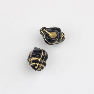 Macro detail of conch-shaped black glass beads with vintage gold foil texture lines