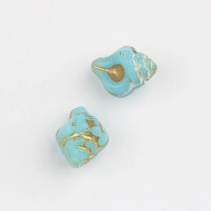 Macro detail of turquoise glass conch shell beads with gold foil for DIY jewelry making