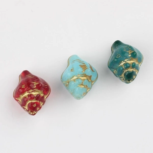 Detailed macro view of conch-shaped Czech glass beads with gold painted accents