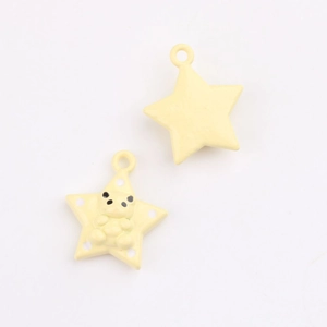 Detail of yellow star-shaped alloy pendants with bear motifs for DIY jewelry making
