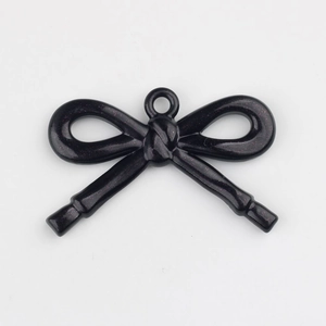 Detalle de colgante de lazo negro con purpurina para creación de joyería artesanal