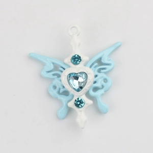 Détail macro du pendentif papillon en émail bleu ciel avec des pierres de zircon en cœur