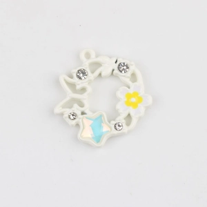 Dettaglio del ciondolo a ghirlanda floreale smaltata con zirconi e stella blu per gioielli DIY