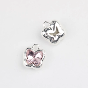Detailed macro view of pink crystal butterfly pendant with silver plating for DIY jewelry