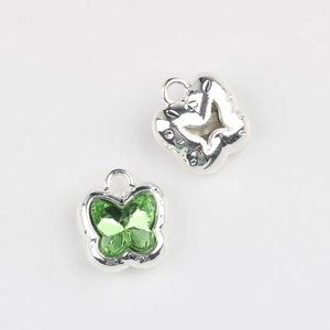 Detail of silver alloy butterfly charms featuring vibrant green zircon stones for DIY jewelry