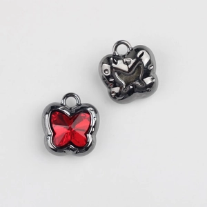 Macro view of butterfly pendant with red crystal stone and gunmetal gray alloy frame