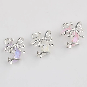 Three glittering resin bow pendants in purple white and pink for DIY jewelry making