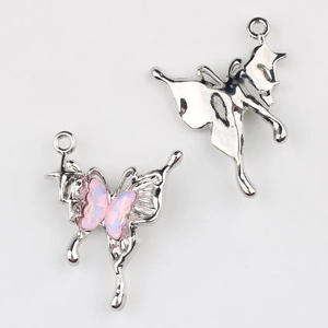 Detalle macro de colgantes de mariposa plateados con resina rosa para joyería DIY