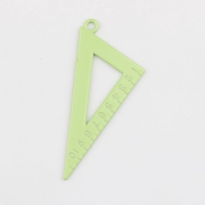 Macro shot of light green alloy triangle ruler charm with precise 1-10 scale markings